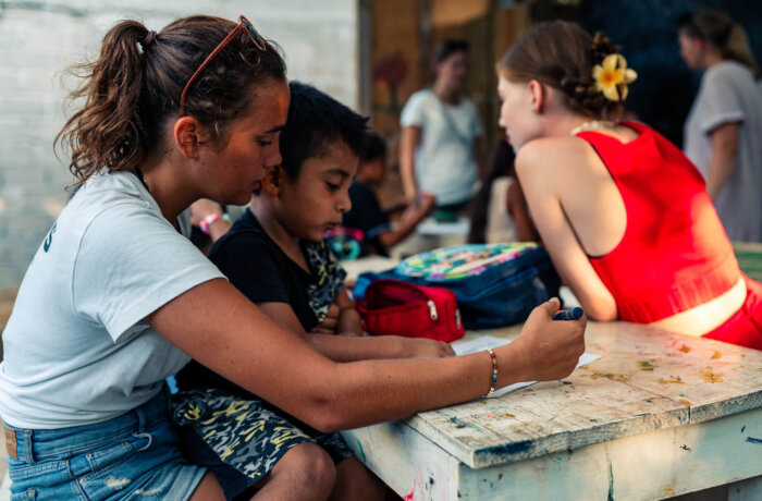 Freiwillige von Wayers helfen Kindern beim Malen in Bildungsprojekt in Lateinamerika