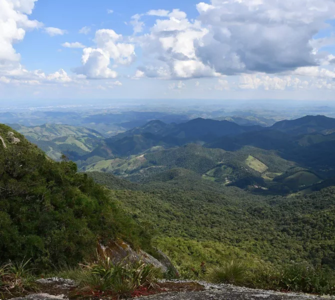 Blick über bewaldete Hügel und Täler unter einem teils bewölkten Himmel im Montverde-Nebelwald.