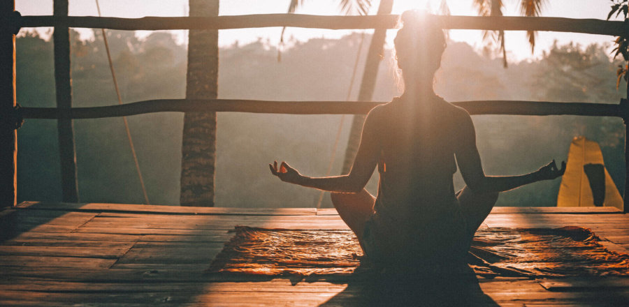 Frau macht beim Sonnenuntergang Yoga, Life-Changer-Reisen, Yoga