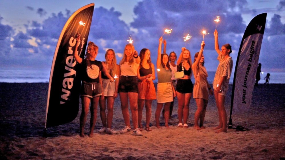 Teilnehmer halten bei Nacht, Wunderkerzen in die Luft