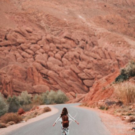 Mädchen läuft auf einer Straße durch die Wüste