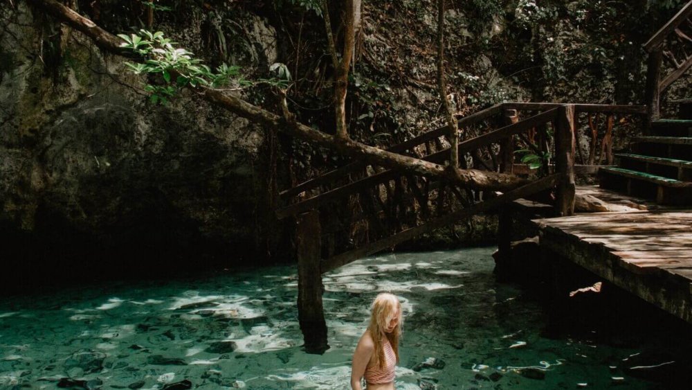 Mädchen badet in einer Cenote