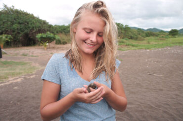 Eine Teilnehmerin hält eine Meeresschildkröte in der Hand