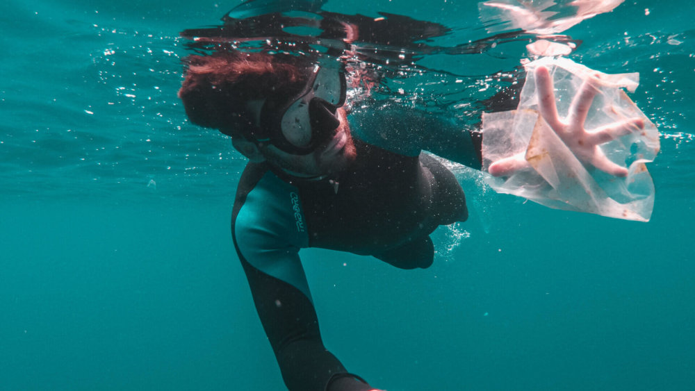 Ein Taucher sammelt den Müll unter Wasser ein