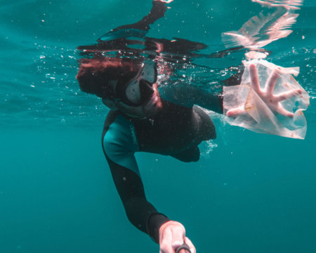 Ein Taucher sammelt den Müll unter Wasser ein