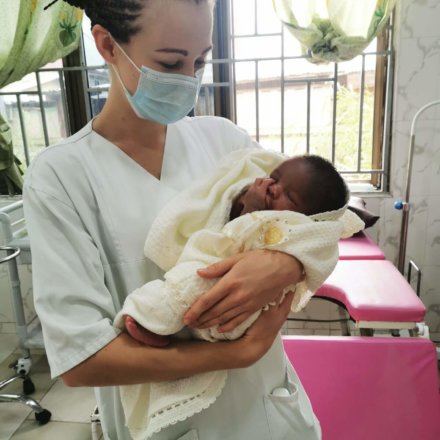 ChatGPT: Pflegekraft hält Neugeborenes im Arm auf Entbindungsstation eines Krankenhauses in Afrika