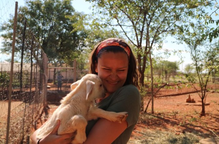 Mädchen hält Ziege auf dem Arm, Freiwilligenarbeit, Namibia, Wildlife-und-Tierschutz