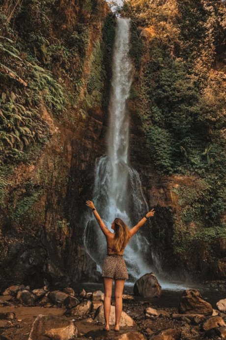 Mädchen steht vor einem Wasserfall, neuseeland, landschaft