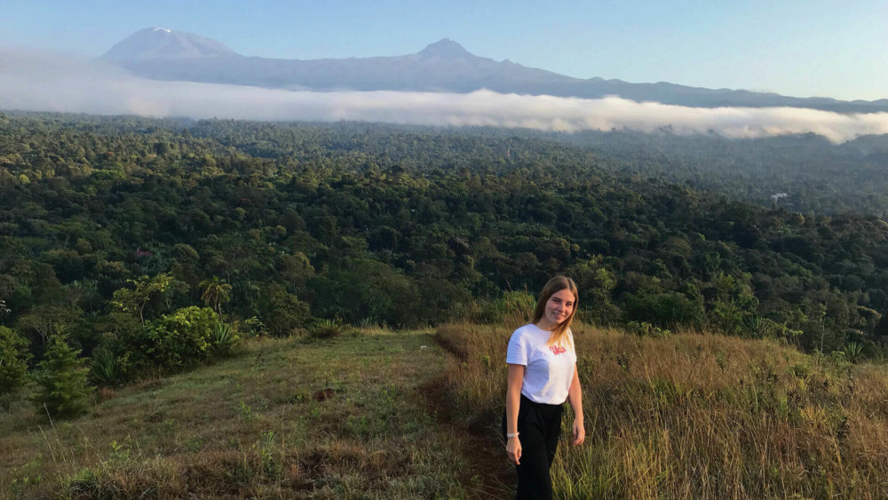 Eine Teilnehmerin auf einem Berg vor dem Kilimanjaro