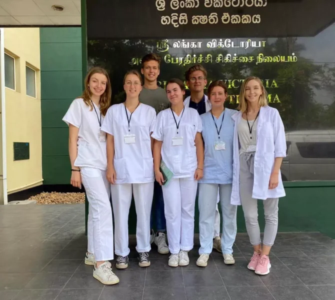 ChatGPT: Medizinstudierende posieren vor Krankenhausgebäude während Praktikum in Sri Lanka
